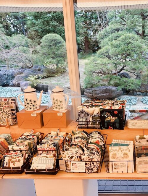 スウェーデン・テキスタイル展のポスターと、特設ショップに並ぶ花柄や動物柄の北欧生地・カットクロス・バッグ・雑貨