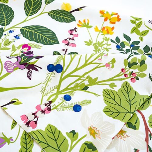 白地に草花やベリーを描いた北欧生地Ångermanlandの大判ファブリックパネルがレストランの壁に飾られた様子