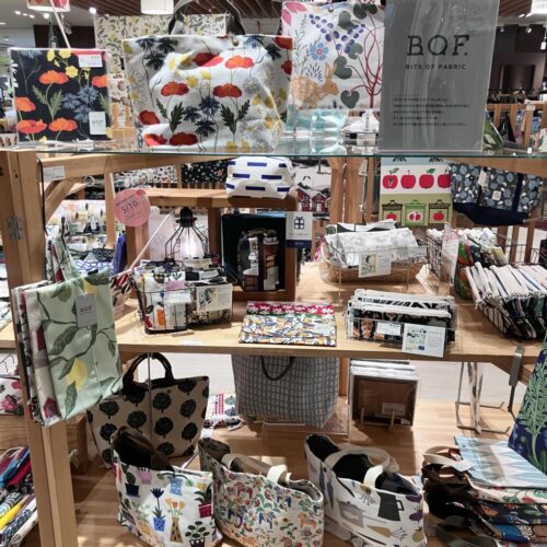 ストライプ地に猫やパンダの刺繍をあしらった扇子と、動物モチーフのカゴバッグが並ぶ店頭ディスプレイ