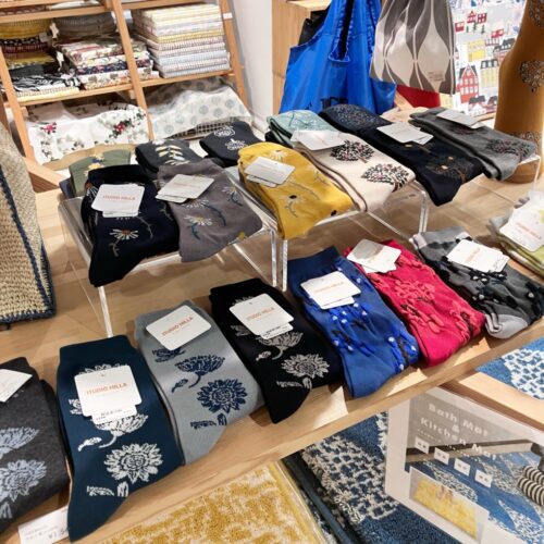 ストライプ地に猫やパンダの刺繍をあしらった扇子と、動物モチーフのカゴバッグが並ぶ店頭ディスプレイ