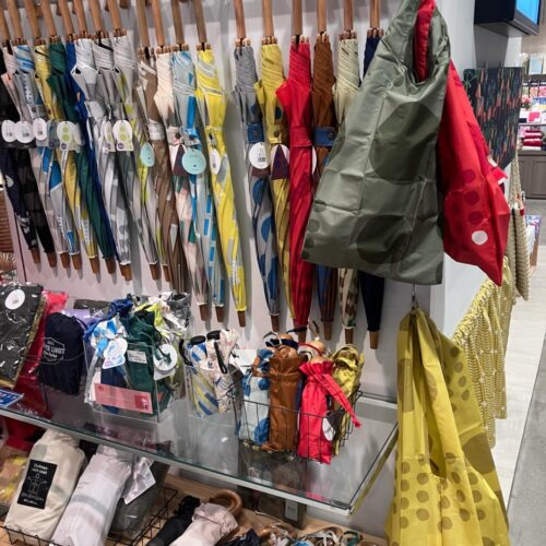 ストライプ地に猫やパンダの刺繍をあしらった扇子と、動物モチーフのカゴバッグが並ぶ店頭ディスプレイ