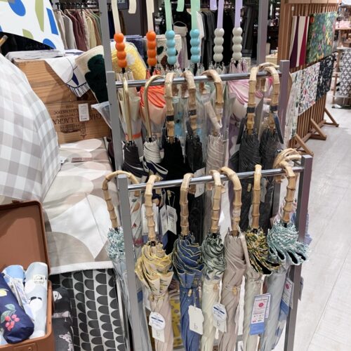 ストライプ地に猫やパンダの刺繍をあしらった扇子と、動物モチーフのカゴバッグが並ぶ店頭ディスプレイ