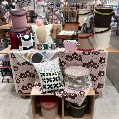 北欧デザインのファブリックやクッション、ストライプ・フラワー柄のマグ、収納雑貨が並ぶ店頭ディスプレイ