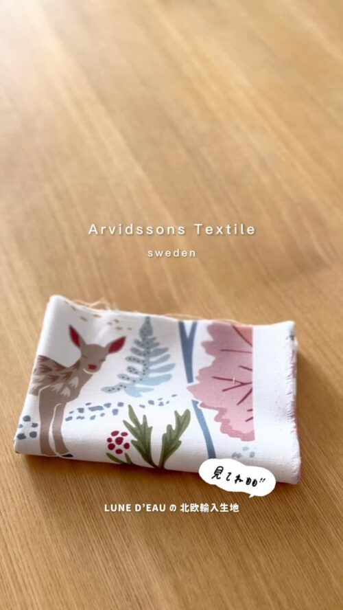 Arvidssons Textileの北欧生地。白地に小鹿とシダ・ベリー・植物をピンクやブルーで描いた柄