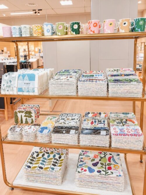 大丸札幌店のルネ・デュー出店ブースに並ぶ羊柄ウールブランケット、北欧植物柄トレー、くじらモチーフのカラフルな雑貨や花柄マグ