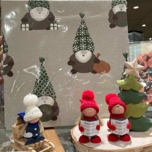 レッドルンズの北欧クリスマス生地。リース柄やトムテ柄、冬の草花柄など赤・ベージュ・ネイビーの多彩な生地が並ぶ様子