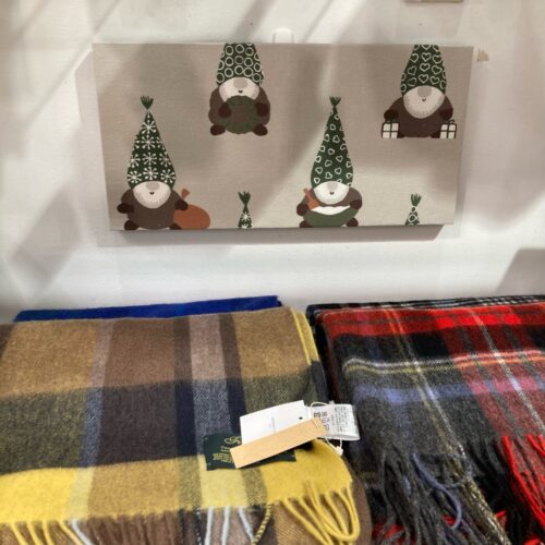レッドルンズの北欧クリスマス生地。リース柄やトムテ柄、冬の草花柄など赤・ベージュ・ネイビーの多彩な生地が並ぶ様子