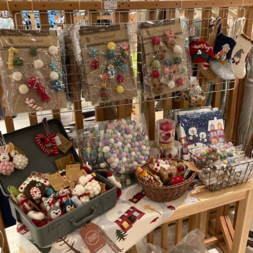 レッドルンズの北欧クリスマス生地。リース柄やトムテ柄、冬の草花柄など赤・ベージュ・ネイビーの多彩な生地が並ぶ様子
