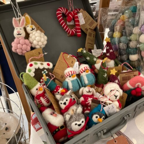 レッドルンズの北欧クリスマス生地。リース柄やトムテ柄、冬の草花柄など赤・ベージュ・ネイビーの多彩な生地が並ぶ様子