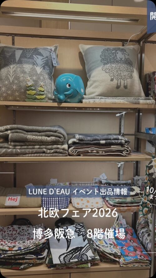 博多阪急の北欧フェア会場。羊柄やモミの木柄のクッション、グレー系ブランケット、北欧柄のファブリック雑貨が棚に並ぶ様子