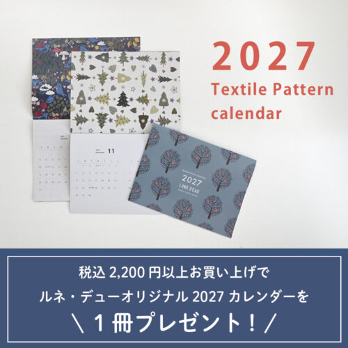 ルネ・デューの2027テキスタイルパターンカレンダー。ブルーグレーの木の柄の表紙と、青い小鳥やモミの木の北欧柄ページ